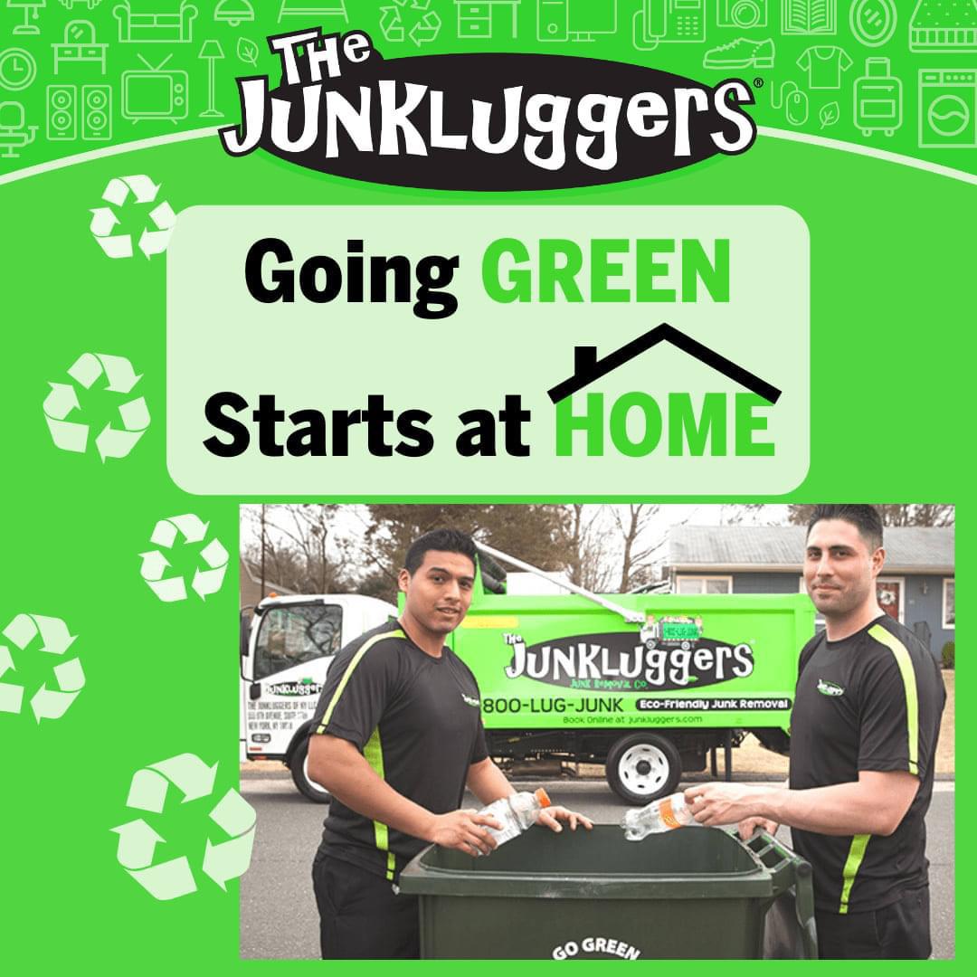 Two "The Junkluggers" employees putting recyclables into a green bin