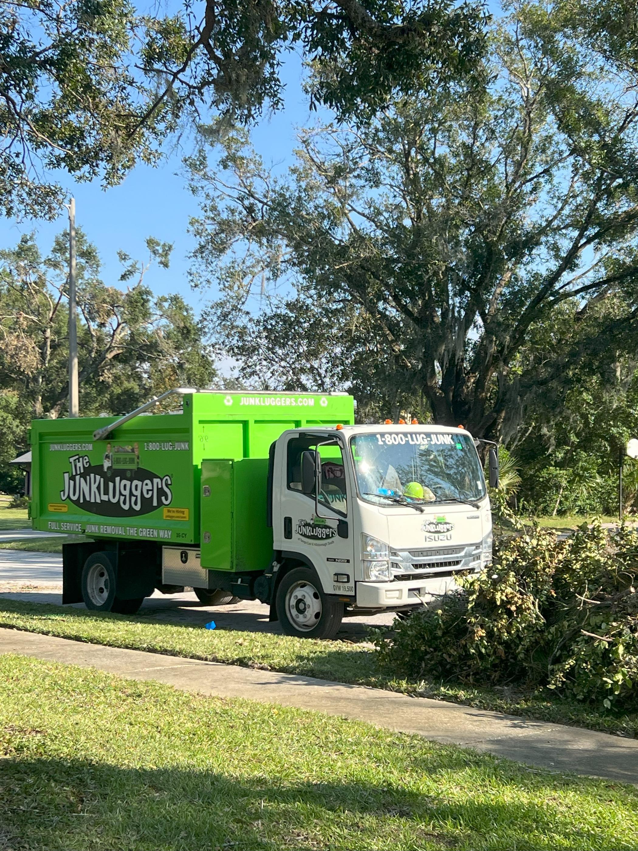 Our Junkluggers truck collecting branches on a residential street