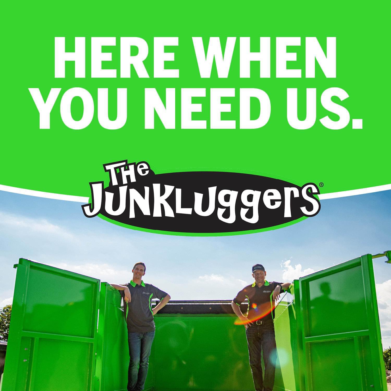 Two Junkluggers team members in open truck under 'Here When You Need Us' sign