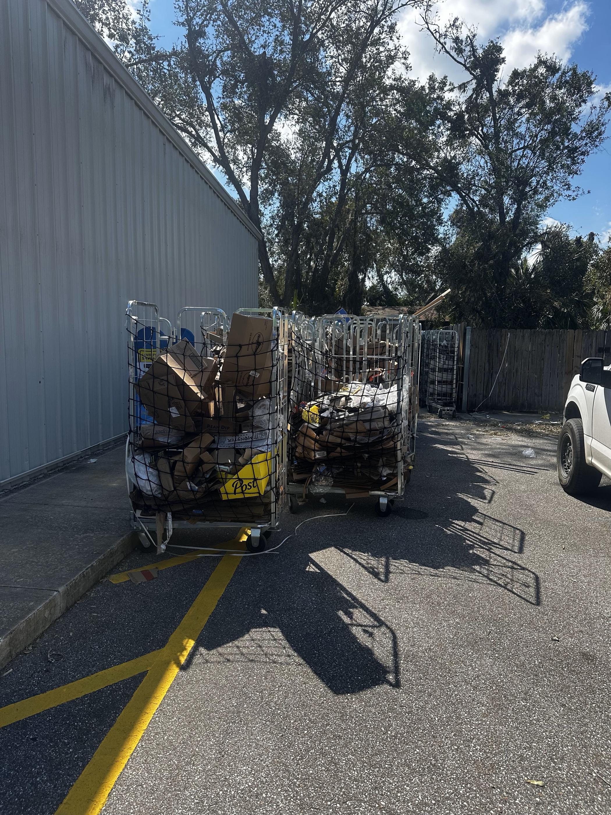 Metal carts filled with paper clutter, including cardboard boxes, packaging materials, and miscellaneous paper waste