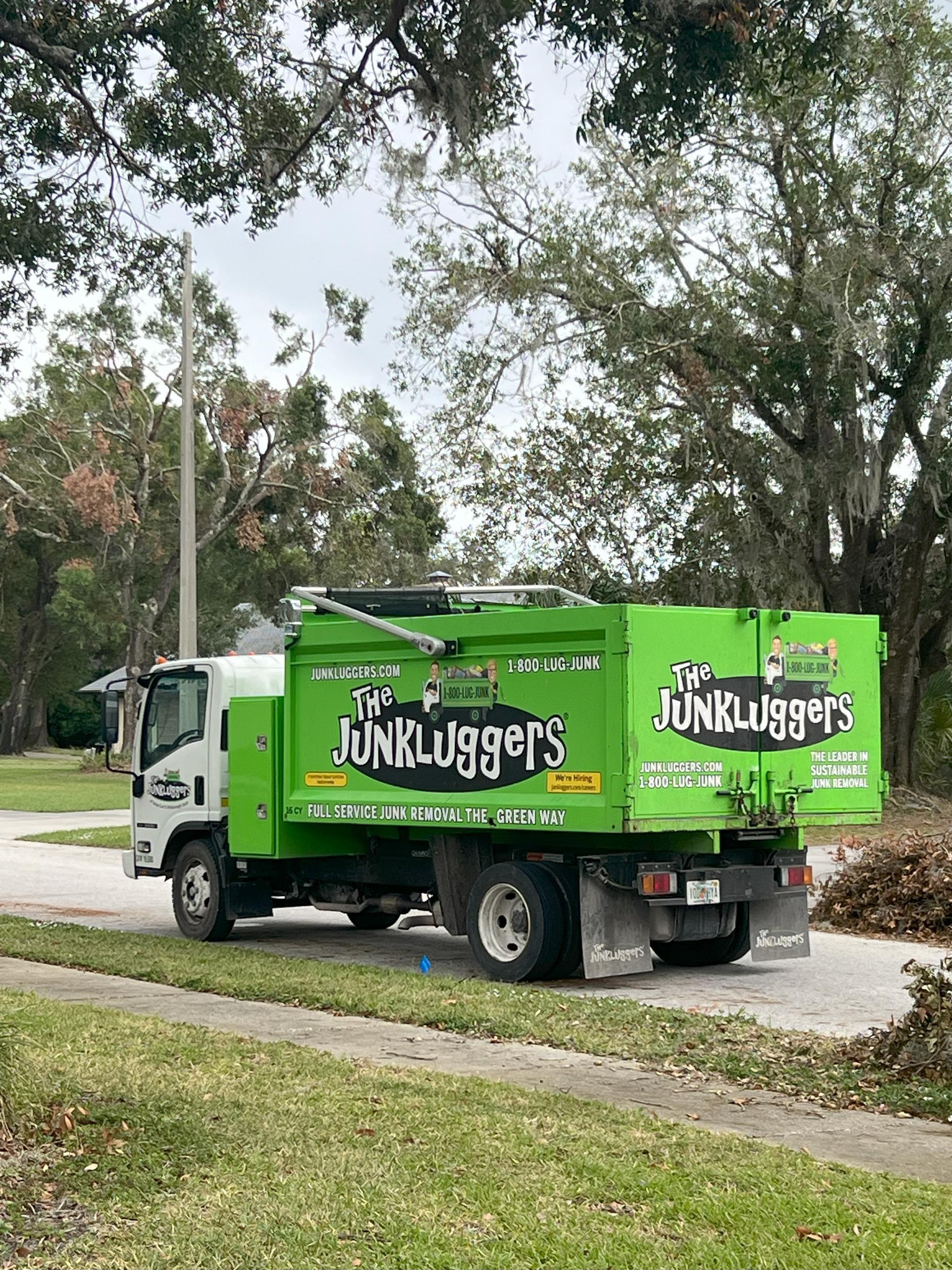 A The JunkLuggers truck parked on a residential street, promoting full-service and sustainable junk removal