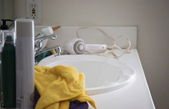 An image of a cluttered bathroom sink and counter