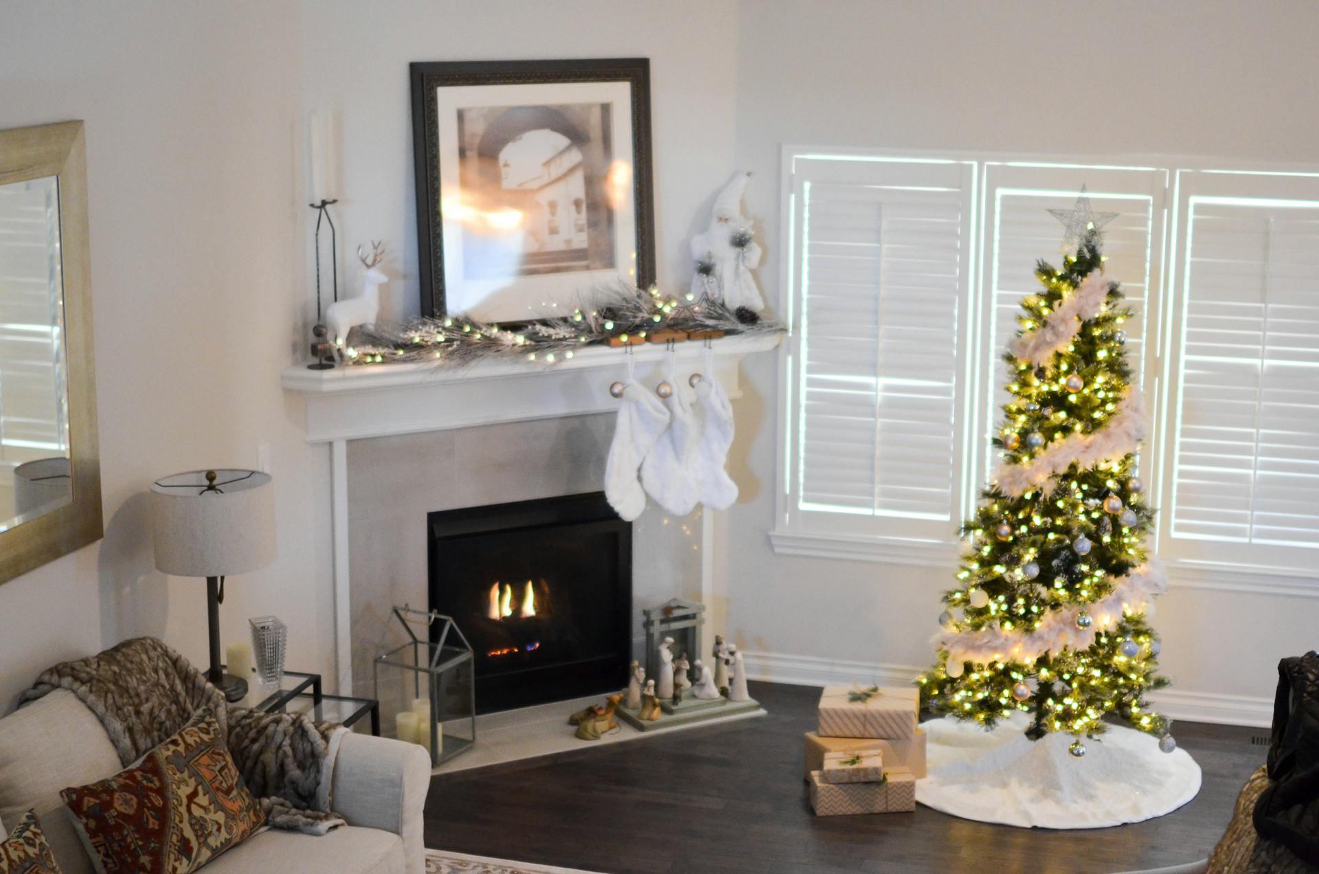 Green and white pre-lit pine tree near fireplace inside well-lit room