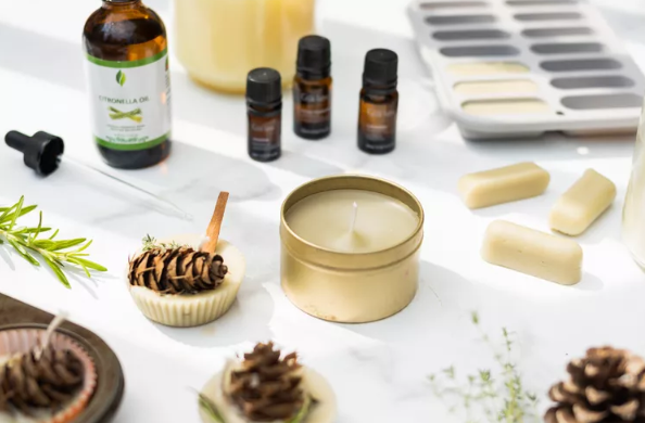 candle surrounded by wax pieces and pincones