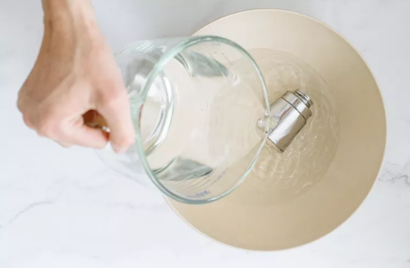 person pouring water on shower head