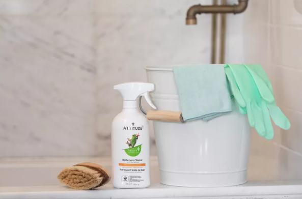white cleaning bucket with green gloves and towels next to all natural cleaner