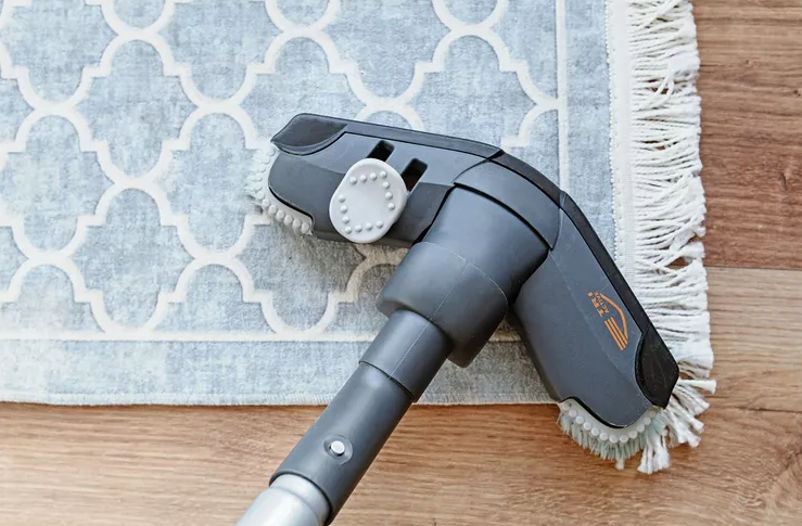 vacuuming over blue and white rug