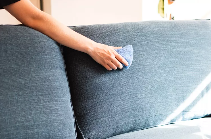 hand scrubbing blue couch