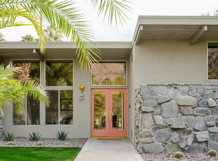 front of house with lots of windows and salmon color door